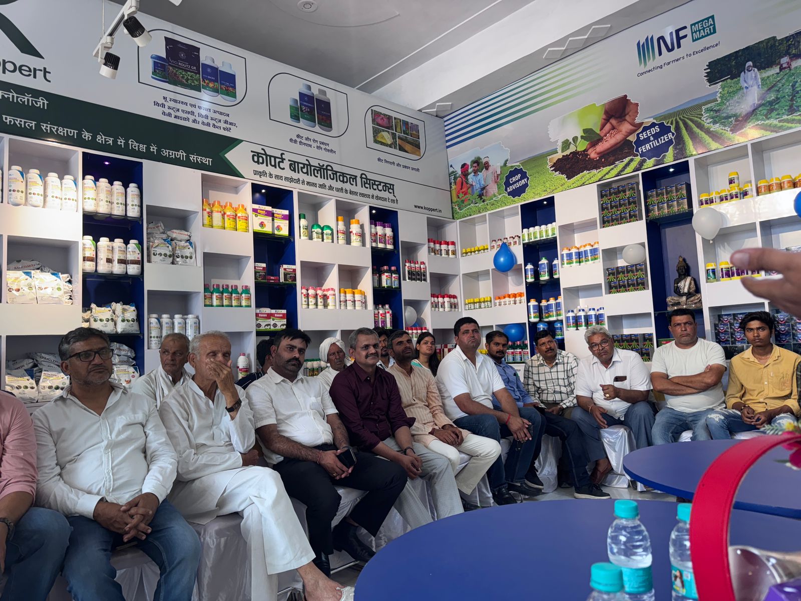 Farmers at retail counter with Koppert biologicals display